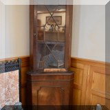 F25. Mahogany glazed corner cupboard.